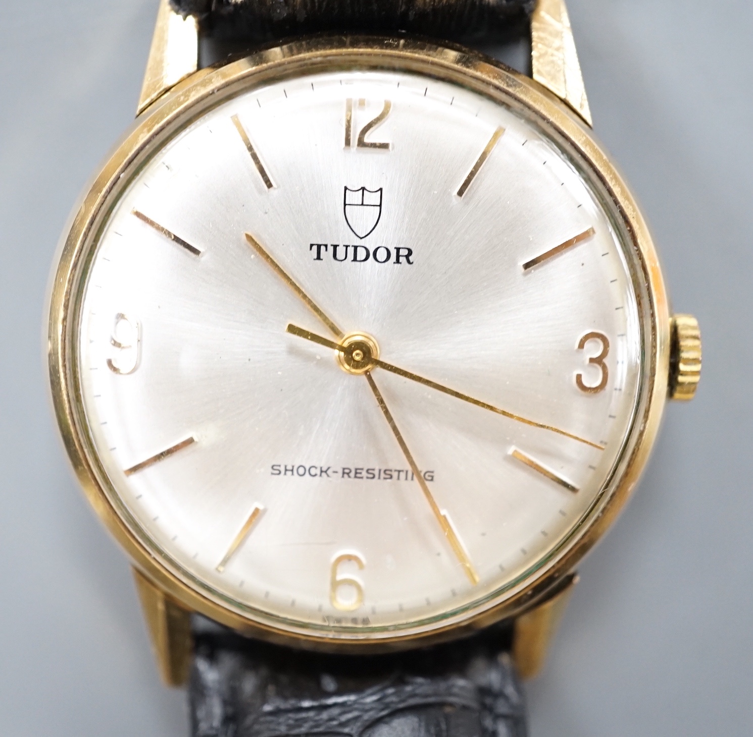 A gentleman's 1970's 9ct gold Tudor manual wind shock-resisting wrist watch, on a black leather strap, case diameter 33mm, with case back inscription